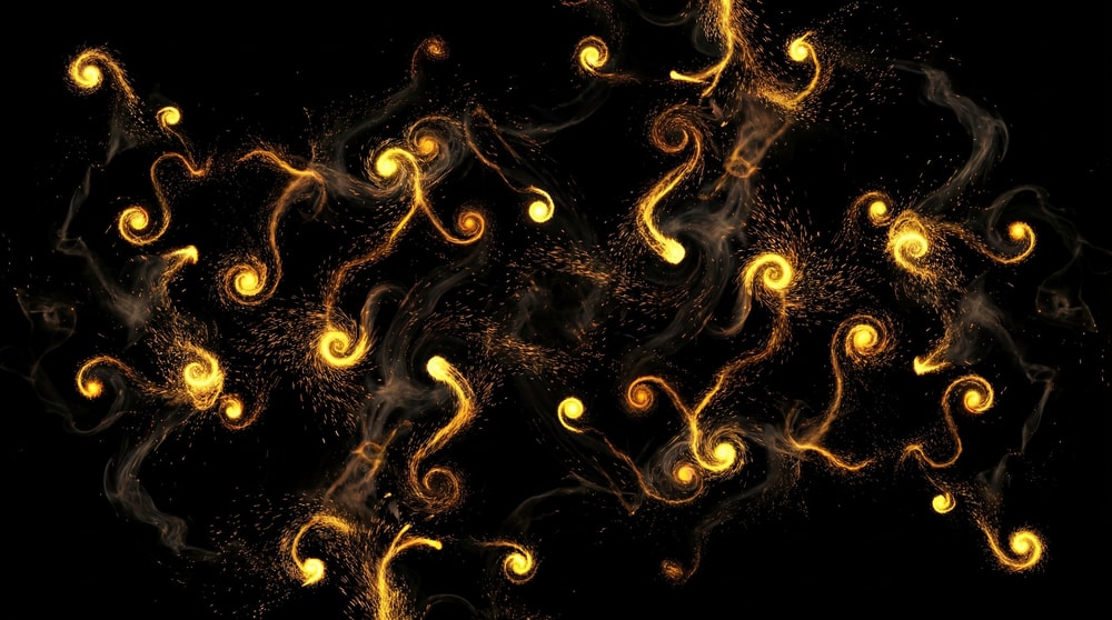 Abstract swirling golden energy streaks with bright points and fine dust motes scattered against a black background.
