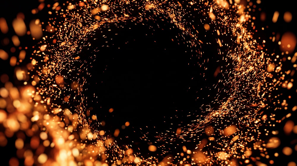 A tunnel-like vortex of swirling golden sparks against a black background.