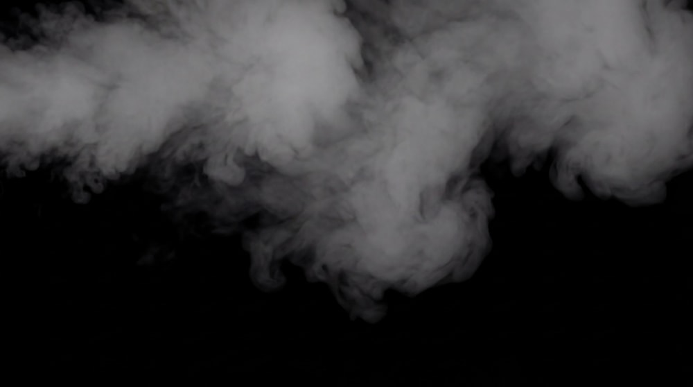 Ethereal wisps of white smoke drifting across a black background.