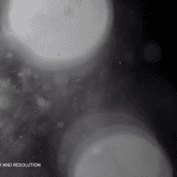 Large soft-focus bokeh circles with subtle particle scatter on a dark background