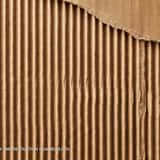 Macro texture of brown shipping cardboard with a torn top layer, revealing the raw, vertical corrugated paper ridges underneath.