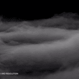 Low-lying horizontal fog bank creeping across the frame against a dark backdrop