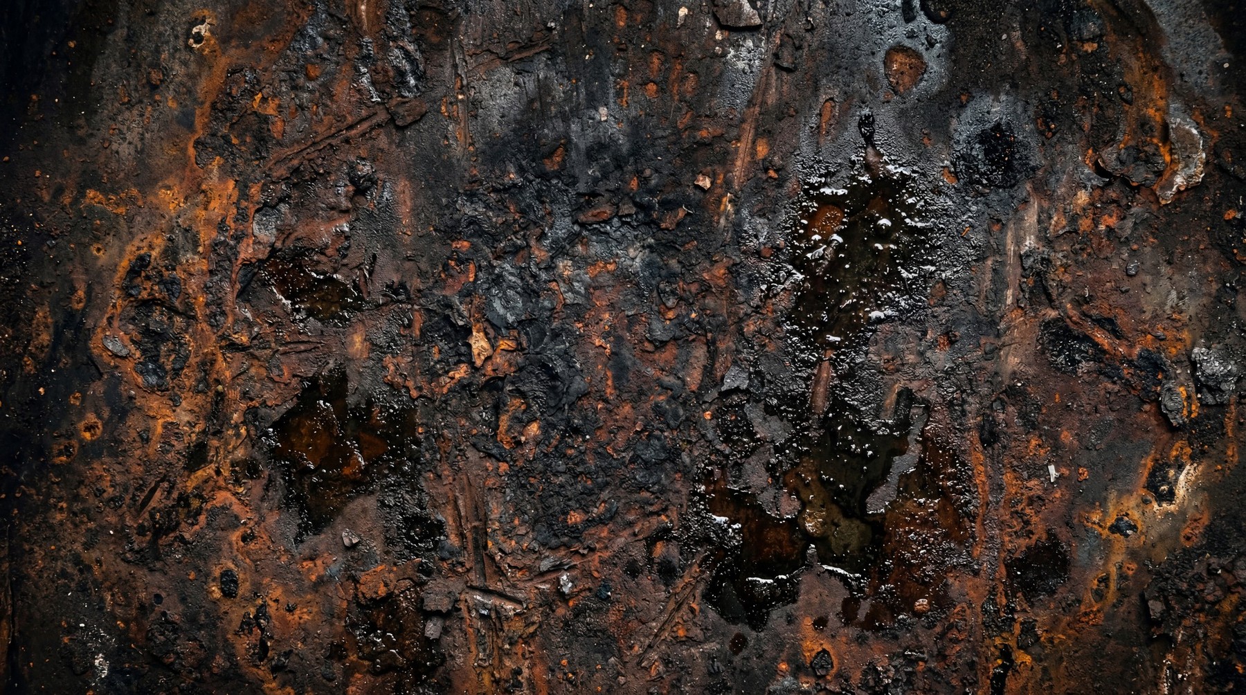 Close-up texture of deep pitted rust and corrosion with black tar-like residue.