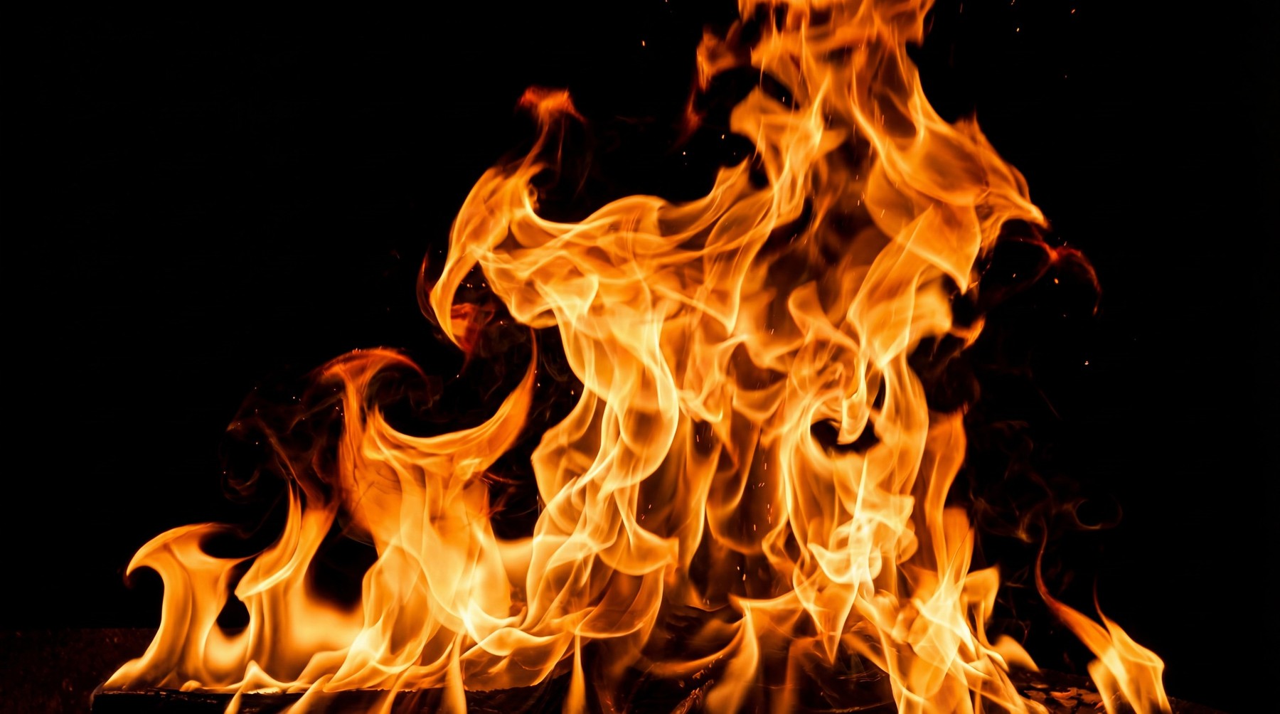 A large, intense column of orange and yellow flames against a black background, with a bright white-hot core at the center.