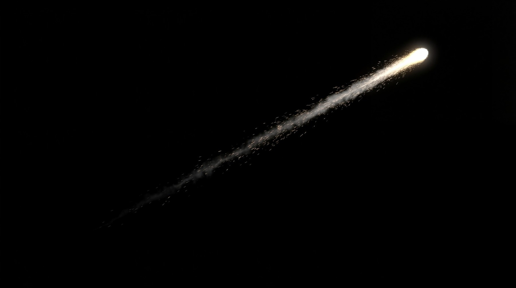 A single bright meteor with a long, fragmented white and yellow glowing trail against a black background.