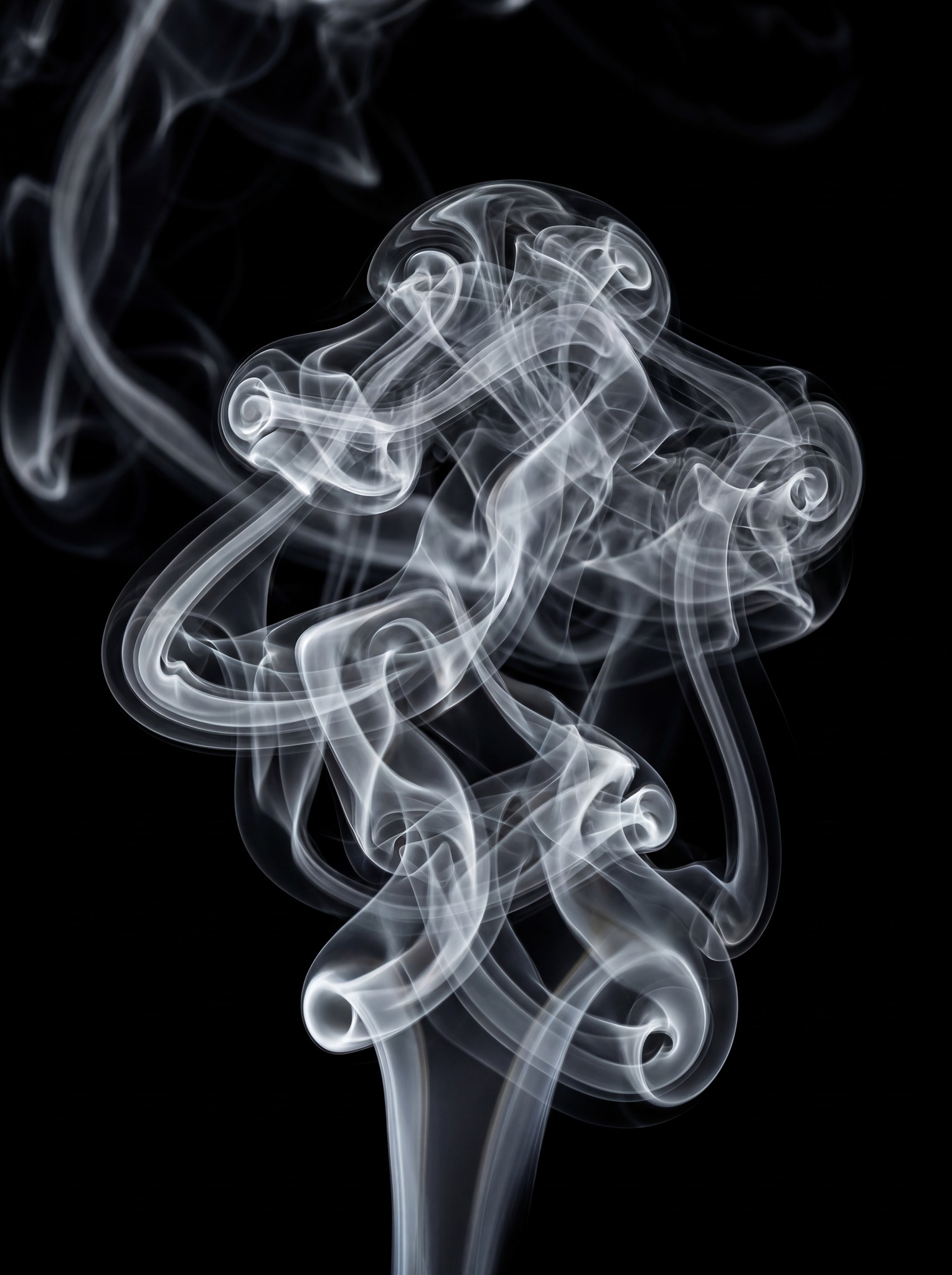 A dense, white smoke column with intricate swirling patterns and loops against a black background.