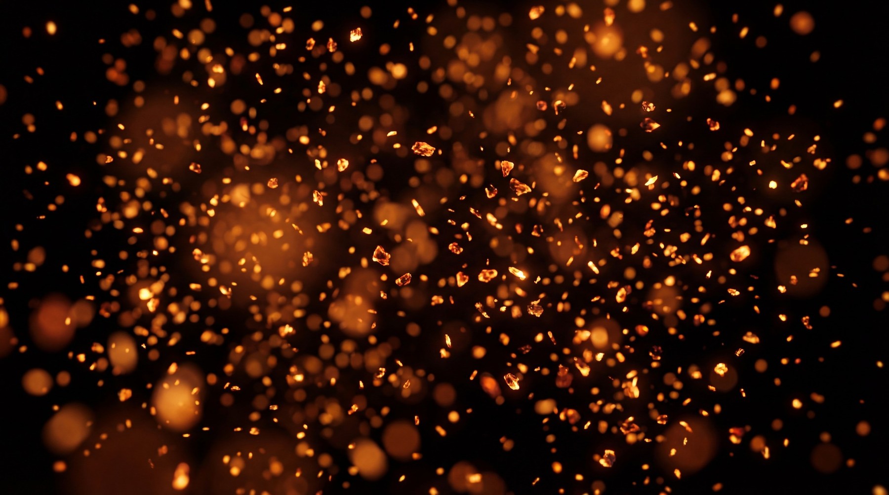 Numerous small, sharp orange embers and sparks scattered against a black background.