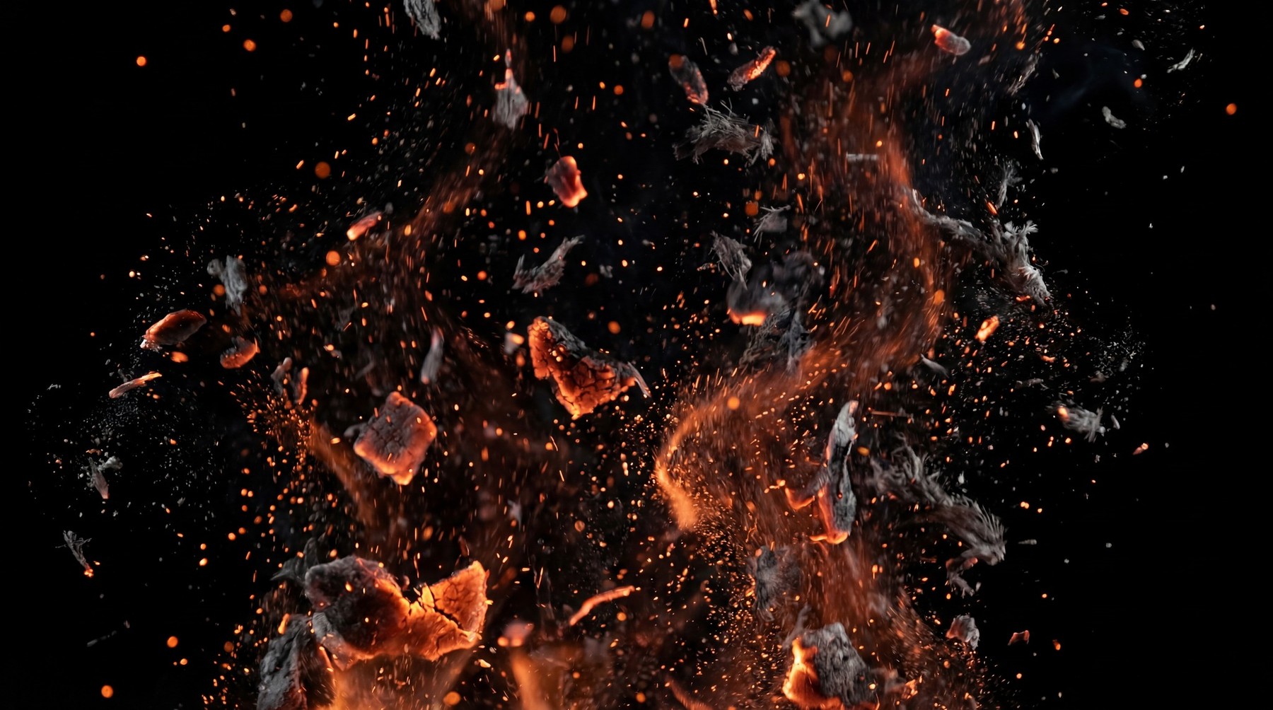 Explosion of glowing orange embers and dark smoke particles against a black background.