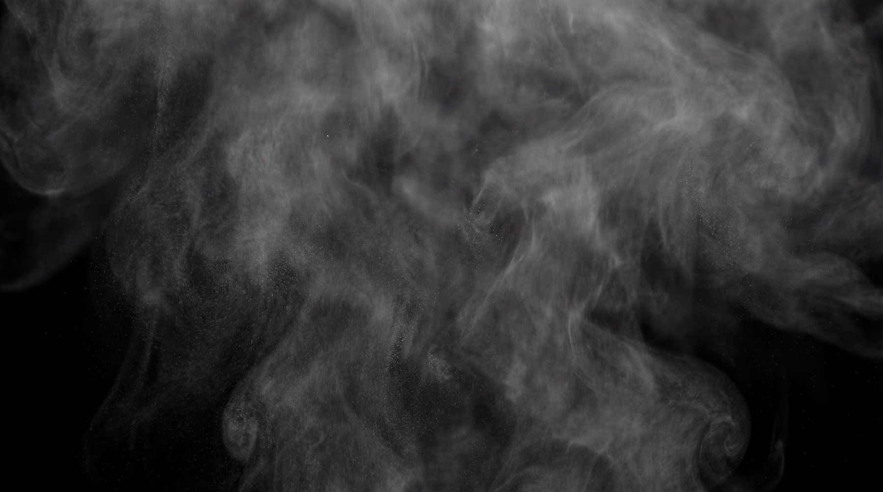 A dynamic, volumetric fog swirl rising from the bottom of the frame against a black background. The fog is medium density with visible tendrils and a sense of upward movement.