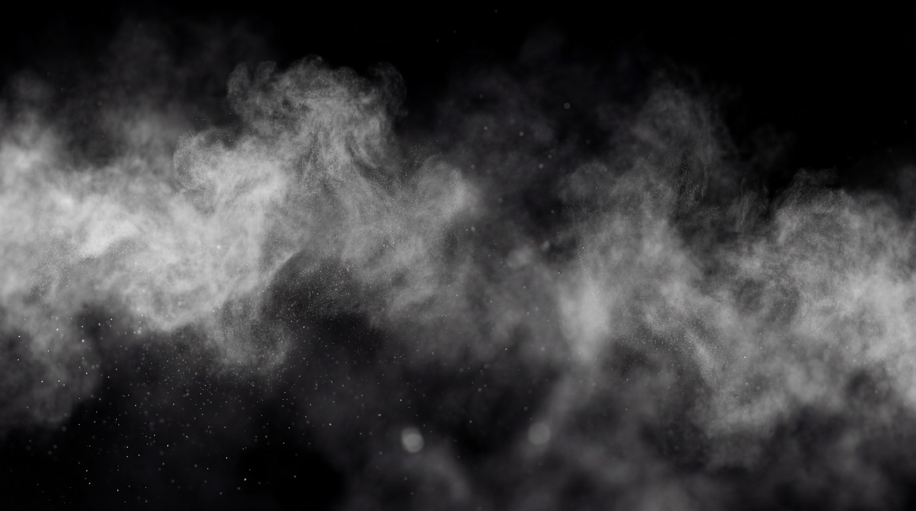 A collection of white, wispy smoke particles drifting across a black background.