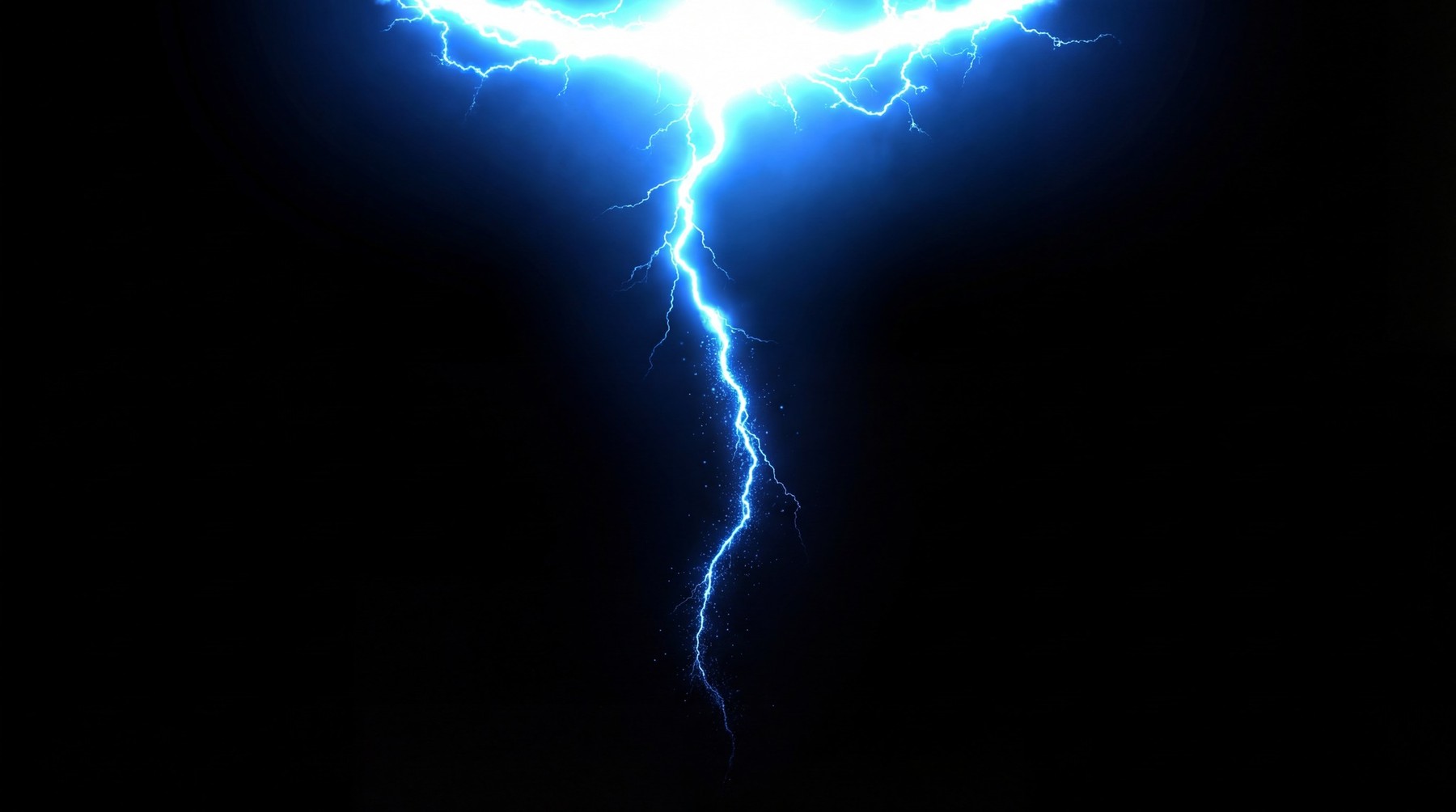 A vivid electric blue lightning bolt striking downwards against a black background, with fine, branching tendrils extending from the main strike.