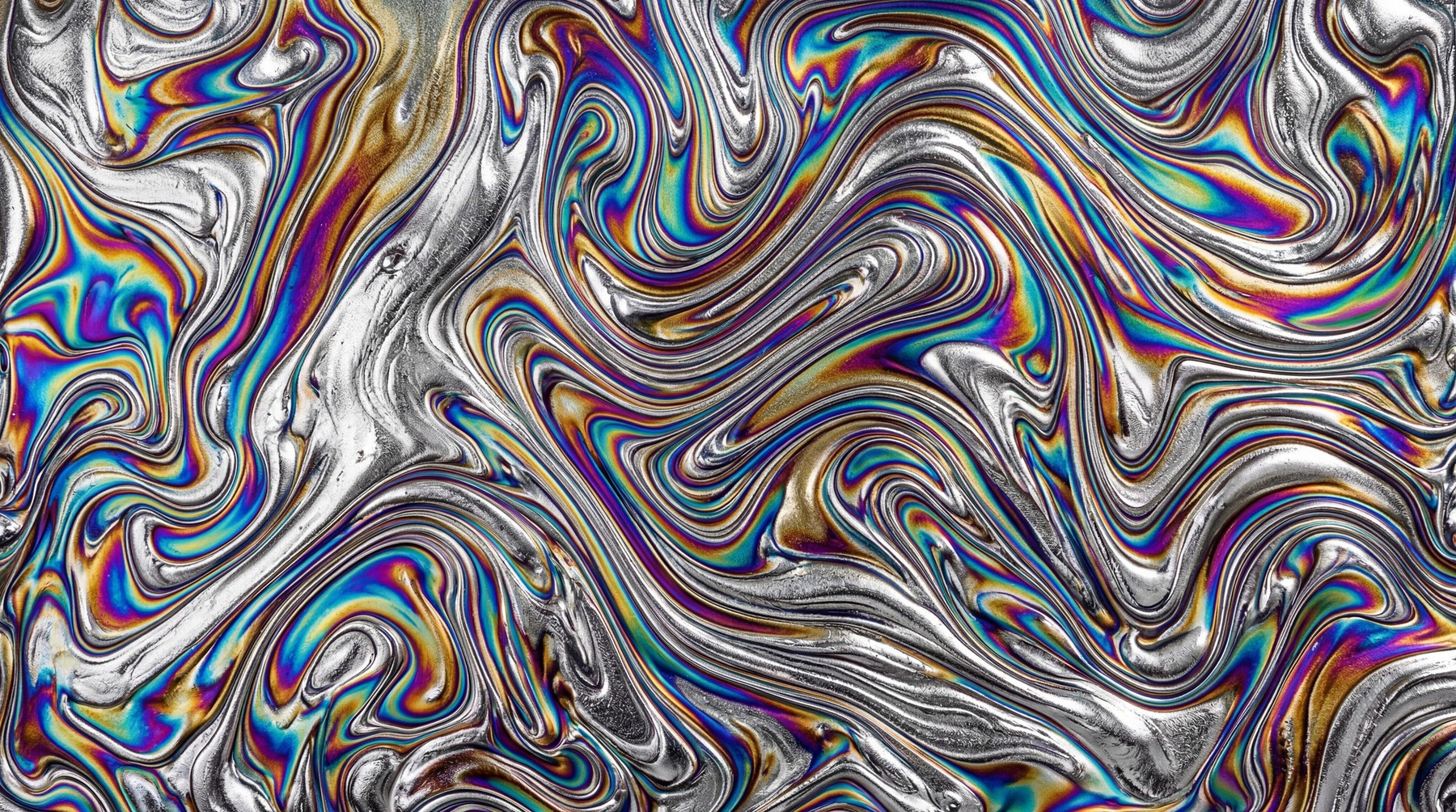 Abstract texture with swirling patterns of iridescent colors, resembling oil on water.